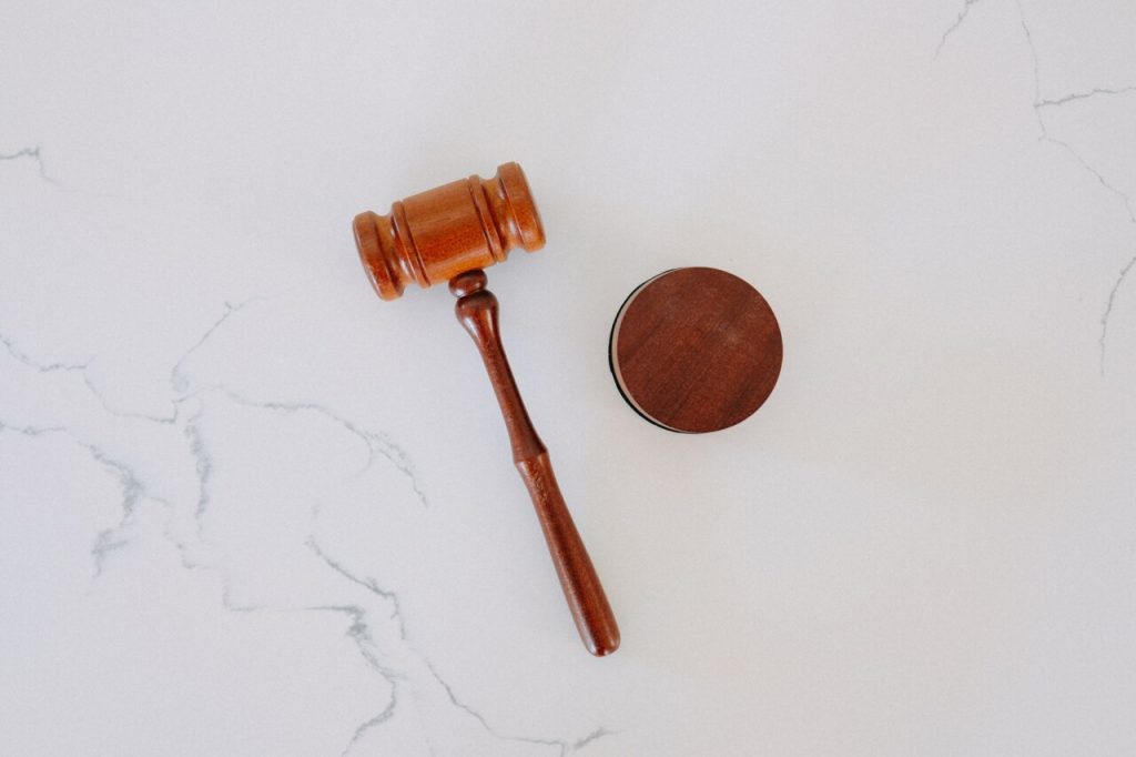A wooden judge’s gavel and sound block rest on a white marble surface, symbolizing the authority at the heart of every effective Risk Management Program.