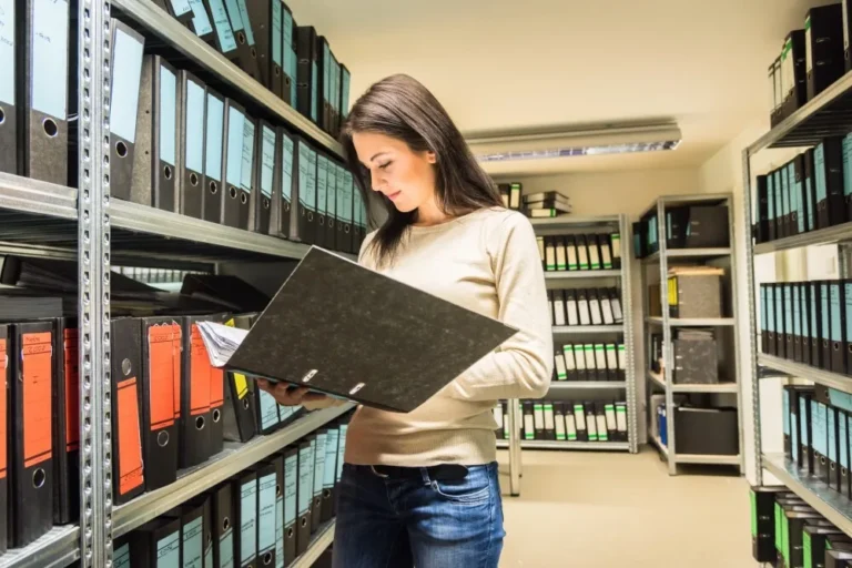 Woman looking at files to prevent environmental compliance costs with software