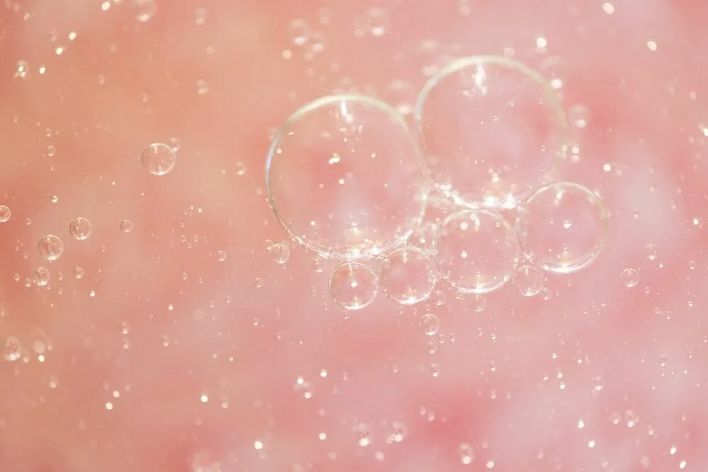 Clear bubbles floating against a soft, blurred pink background evoke the fresh perspective of a Sustainability Committee.