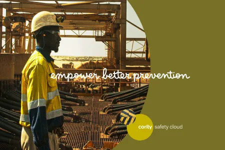 A worker in safety gear stands at an industrial site with the text empower better prevention, highlighting the impact of an effective EHS training program.