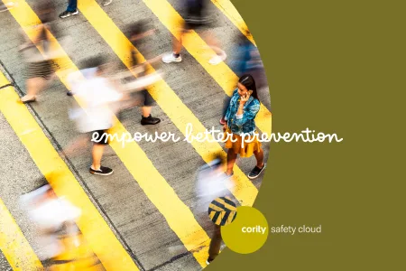 A woman stands on a crosswalk as blurred people walk by; text reads empower better prevention and address safety risks.