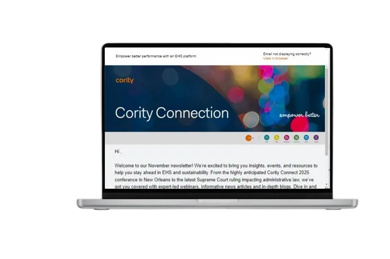 A laptop displaying the Cority Connection newsletter on its screen, featuring a dark blue header, colorful graphics, and a welcome message for the November edition—inviting you to subscribe for future newsletter updates.
