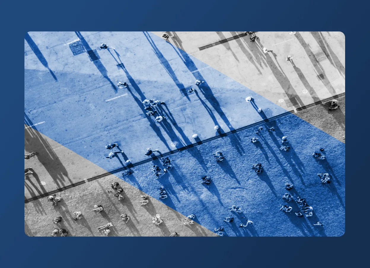 Aerial view of people walking on a pavement, casting long shadows. Blue geometric shapes overlay part of the scene, reminiscent of an Accordion Section layout. The background is framed by a rounded blue border.