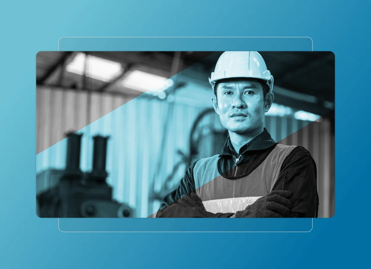 A male industrial worker wearing a hard hat, safety vest, and gloves stands confidently with arms crossed in a factory setting, enhanced by blue graphic elements inspired by a Cloud Accordion Section.