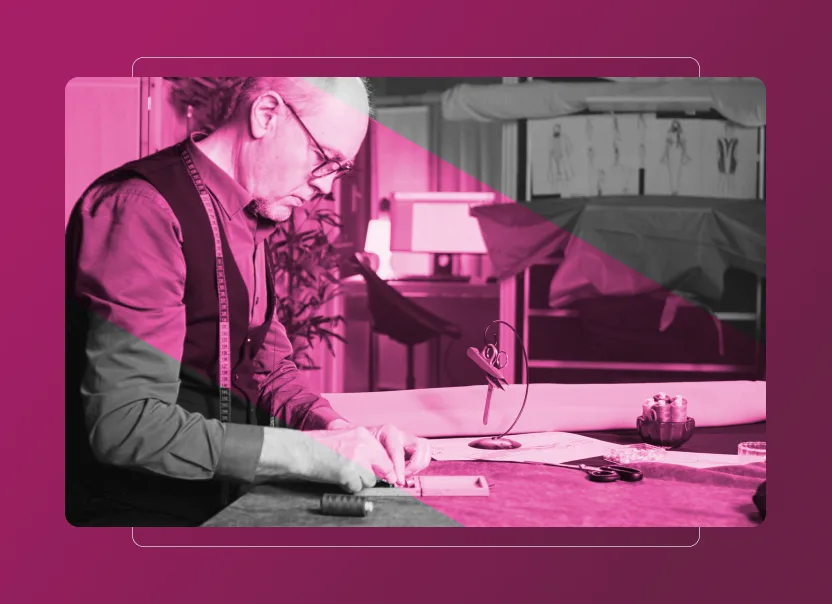 A tailor wearing glasses and a tape measure around his neck works at a table with fabric and sewing tools, in a studio with sketches on the wall. The image features a pink overlay, geometric shapes, and hints of Sustainability Cloud-inspired design.