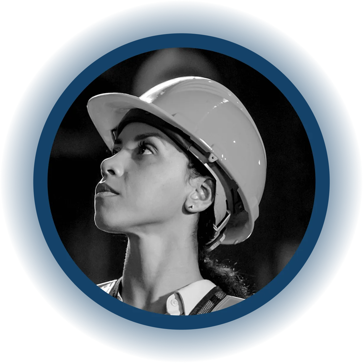 A woman wearing a hard hat and safety vest looks upward with a focused expression, set against a dark background and framed by a blue circular border, embodying the dedication seen in users of EHS software.